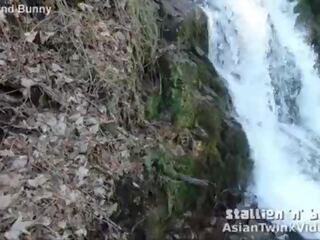 الآسيوية طرفة عين تمتص فم بواسطة waterfall